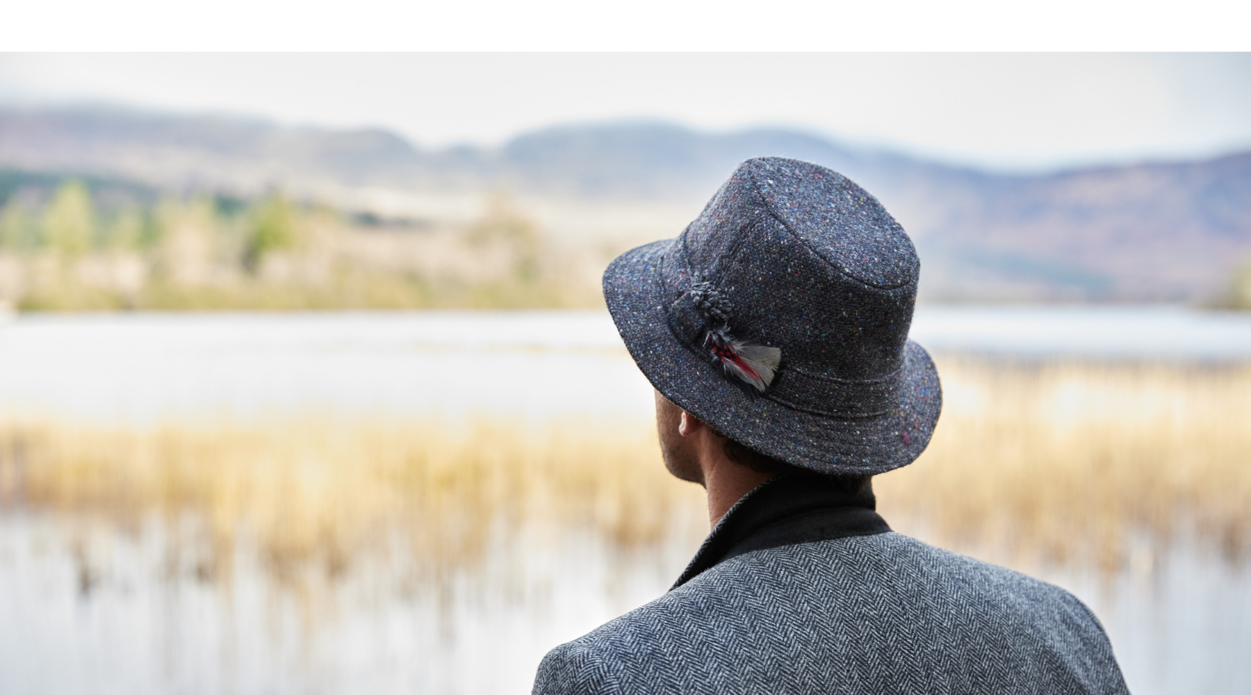 Adam wearing a Navy Tweed Hat pictured at an Irish lake.