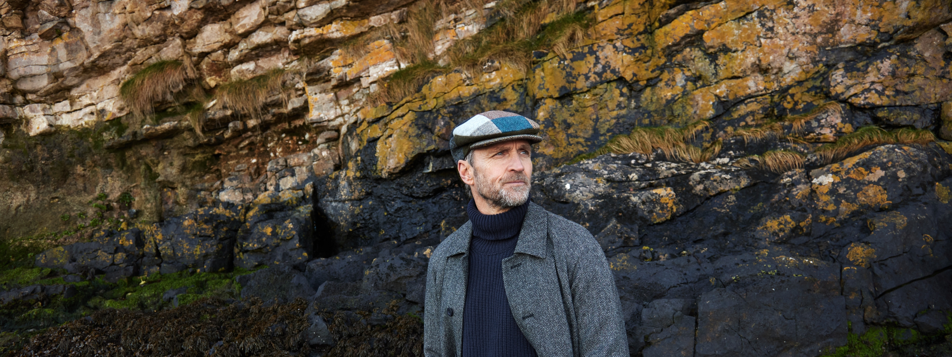 Finn wearing Irish Flat Cap with a grey coat and black sweater.