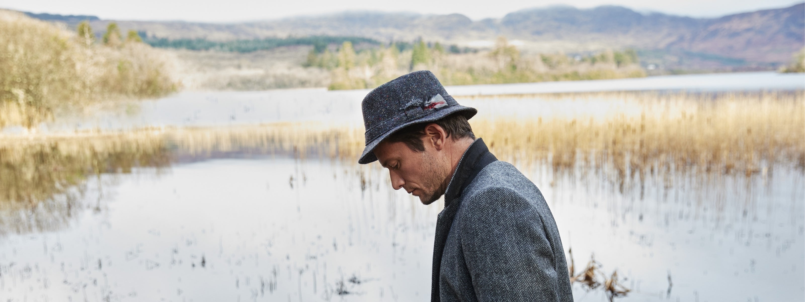 Adam wearing a Navy Tweed Hat pictured at an Irish lake.