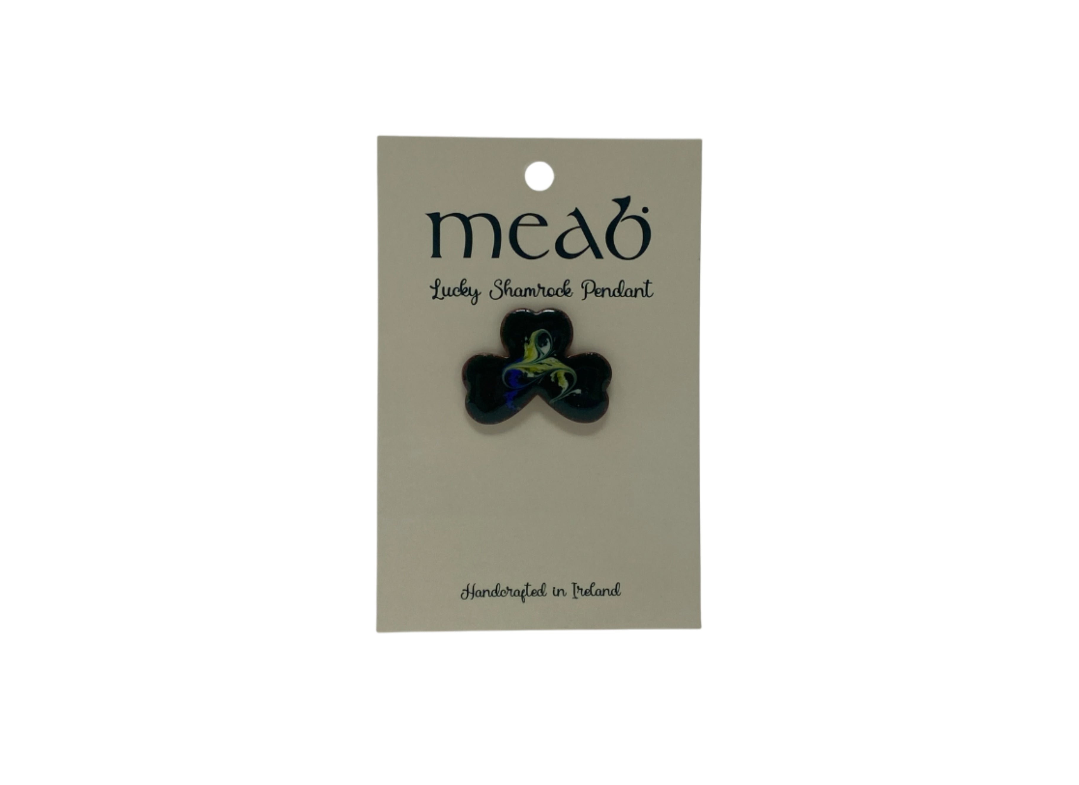 The Meab Enamels Lucky Shamrock Pendant by Hanna Hats of Donegal Ltd features a black shamrock-shaped pendant with metallic green and blue swirls, handcrafted in Ireland from recycled copper using open fire enamelling. Card reads “Lucky Shamrock Pendant.”.