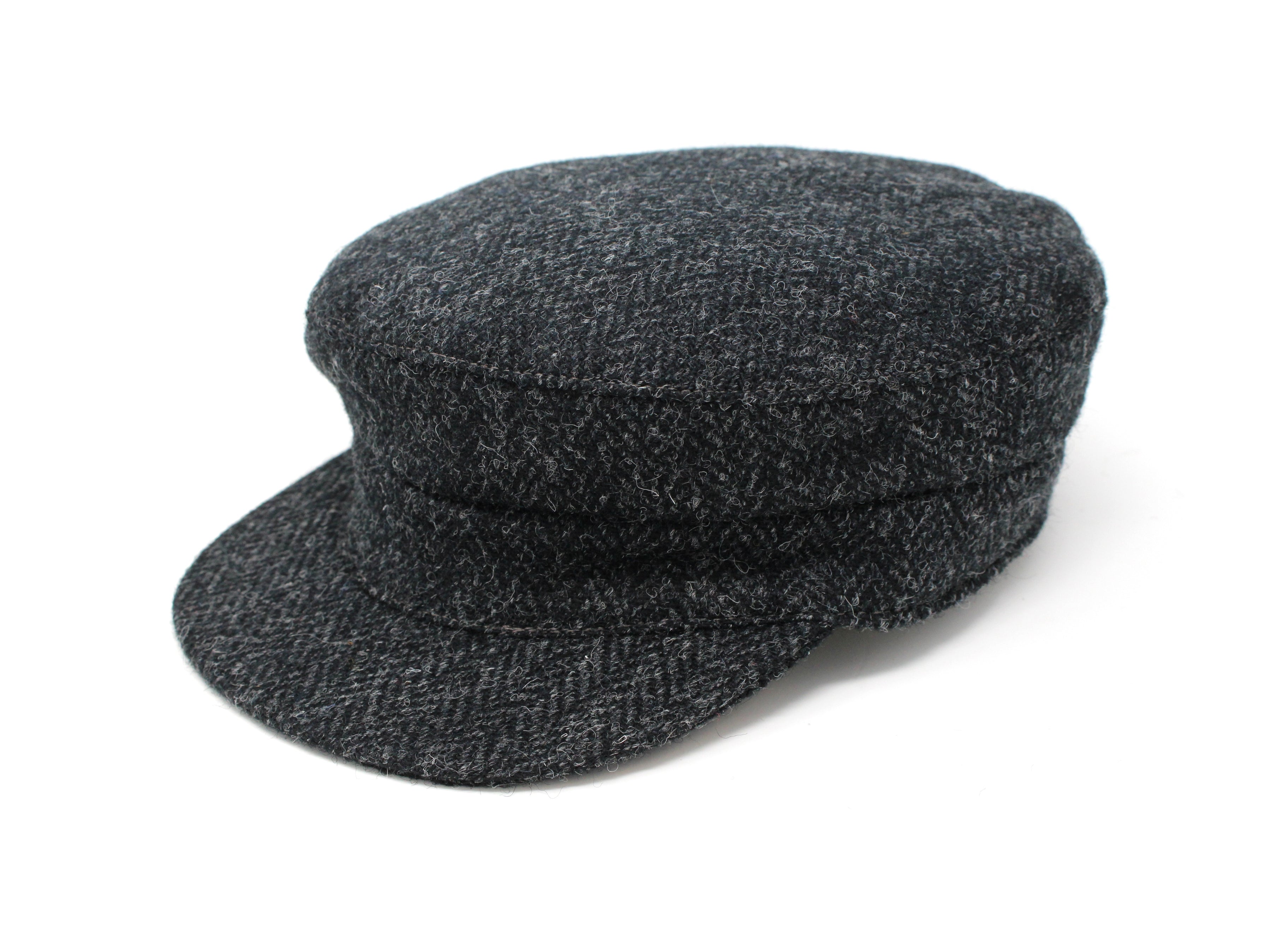 The Hanna Hats Skipper Cap Tweed is a dark gray Irish tweed newsboy cap with a short, curved brim, shown on a white background, inspired by classic mariner style.
