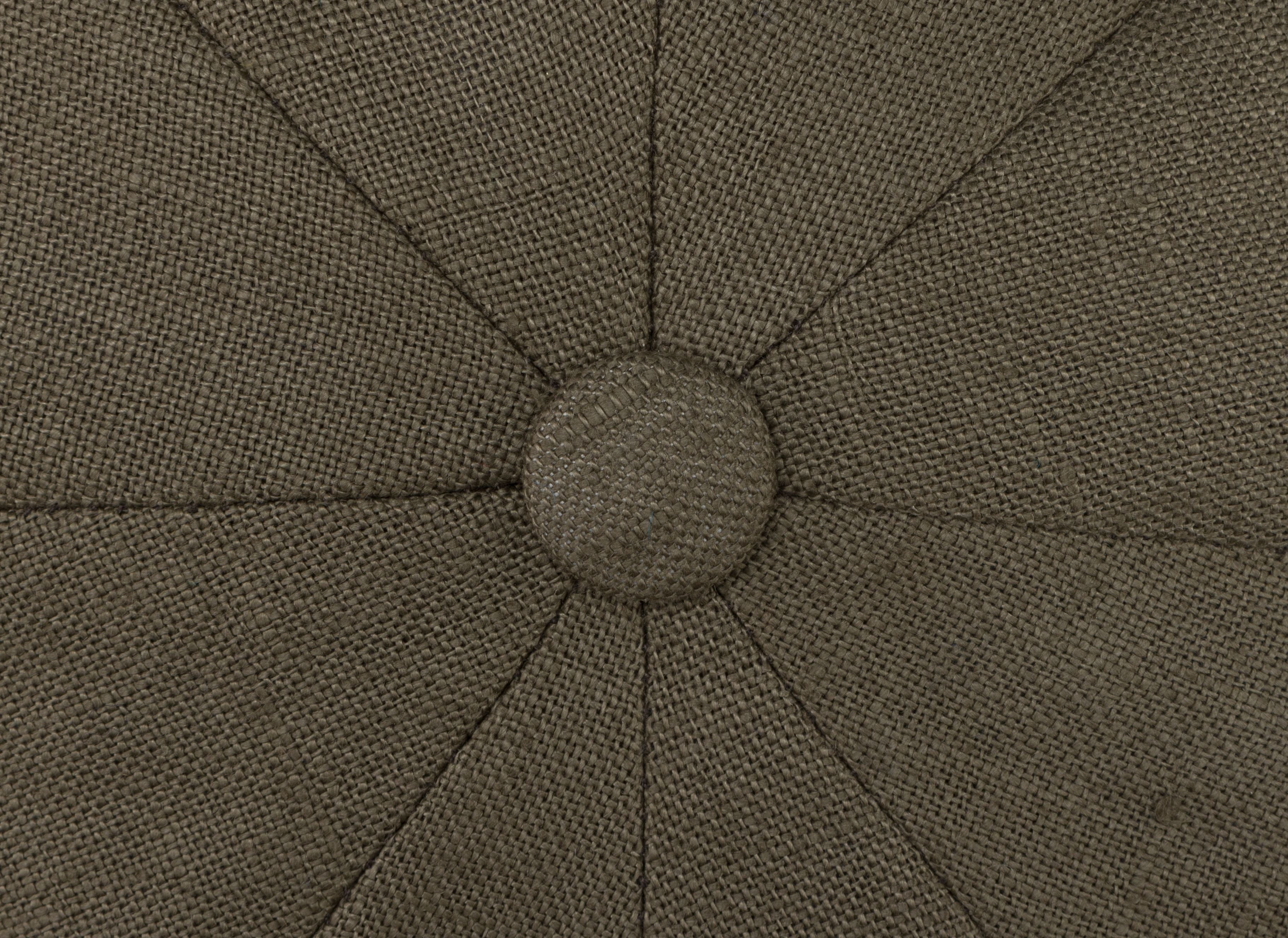 Close-up of textured brown fabric with a central button and radiating seams, evoking the classic Newsboy style featured on the Hanna Hats JP Cap Linen.