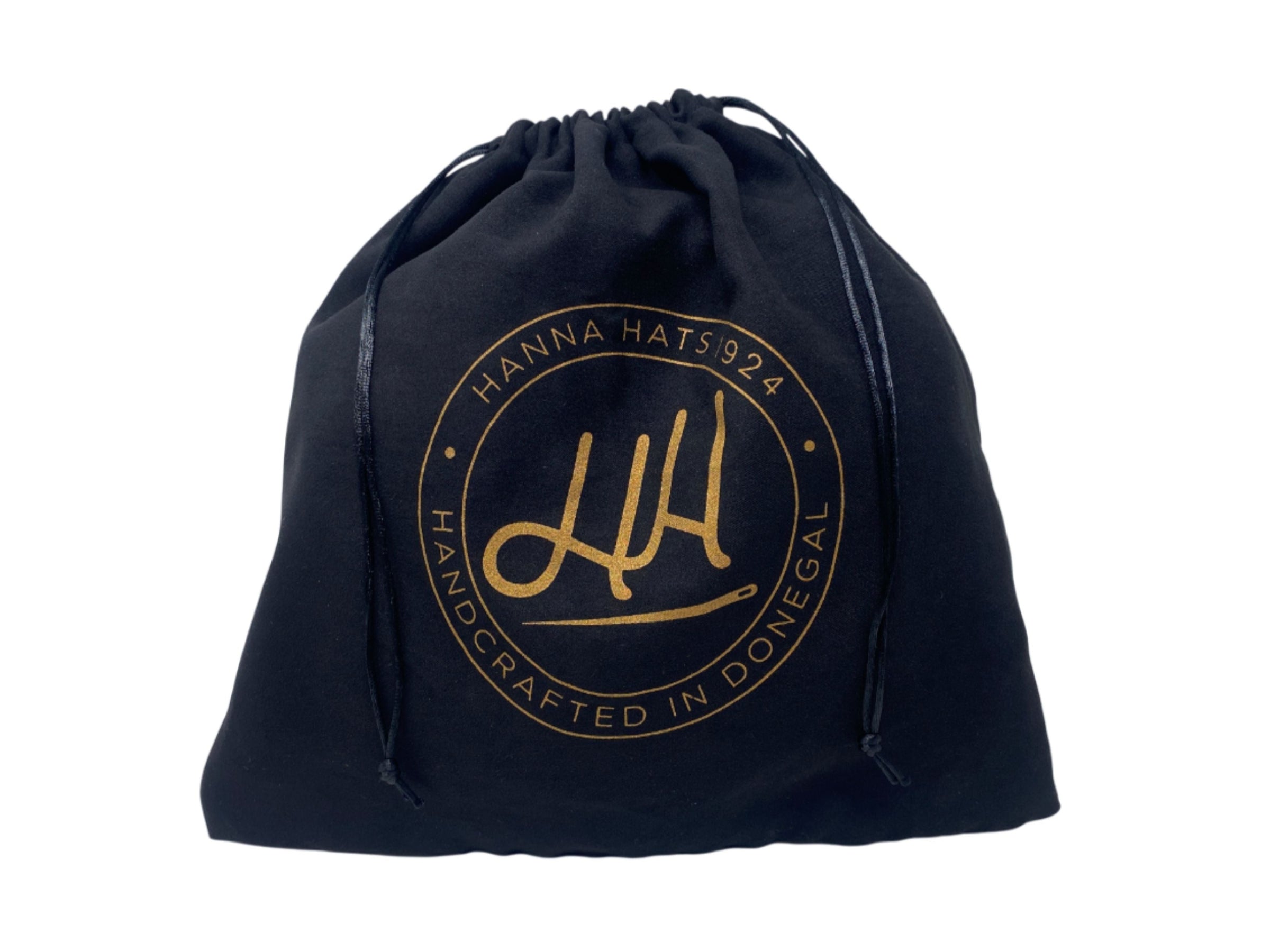 A black Dust Bag by Hanna Hats of Donegal Ltd features a gold circular logo with "HANNA HATS 1924 HANDCRAFTED IN DONEGAL" and stylized initials—perfect for storing caps and protecting hats.