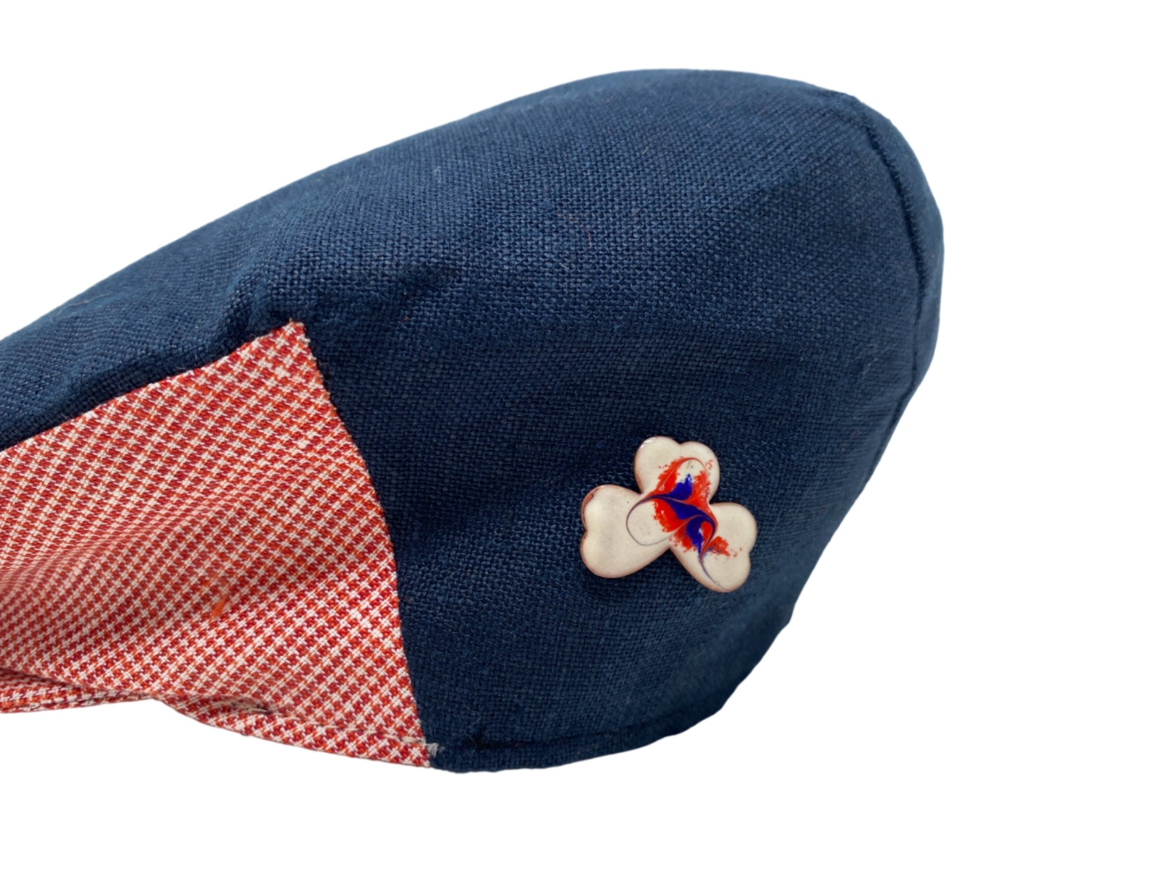 Pair the blue cap with a red and white checkered side panel from Hanna Hats of Donegal Ltd, featuring a flower patch, with the Meab Enamels Lucky Shamrock Pendant Bundle for a charming handcrafted look.