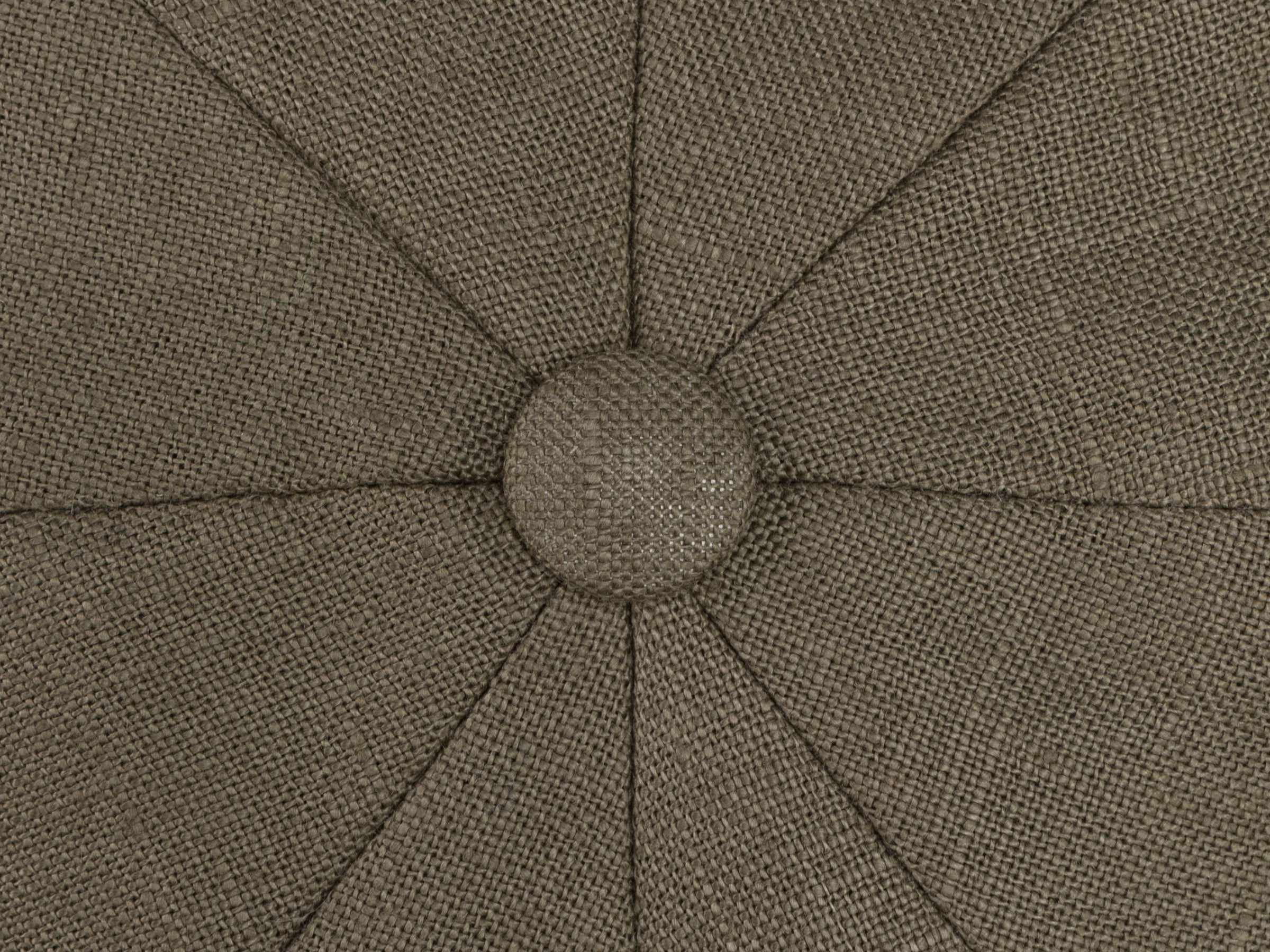 Close-up of textured, brown fabric upholstery inspired by Hanna Hats' Connery Cap Linen, featuring a central button and radiating stitched seams that create a starburst pattern.