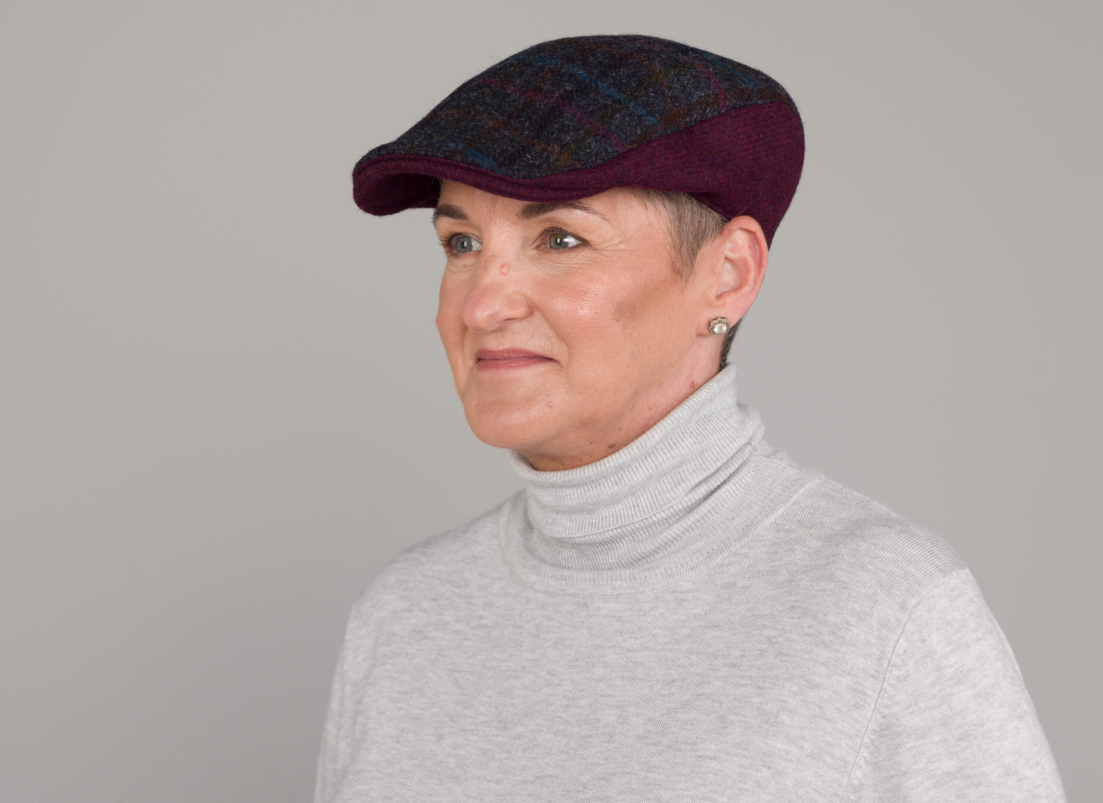Ann wearing Donegal Touring Duo contrast flat cap English Tweed Slate Check with Multicolour Overcheck and English Tweed Mulberry